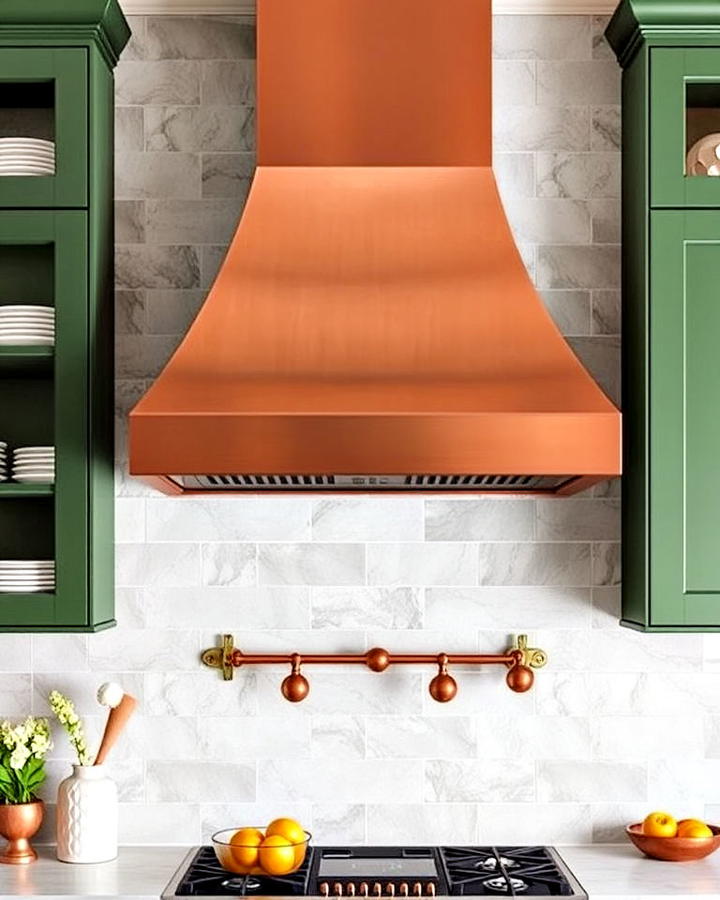 copper range hood with green cabinetry