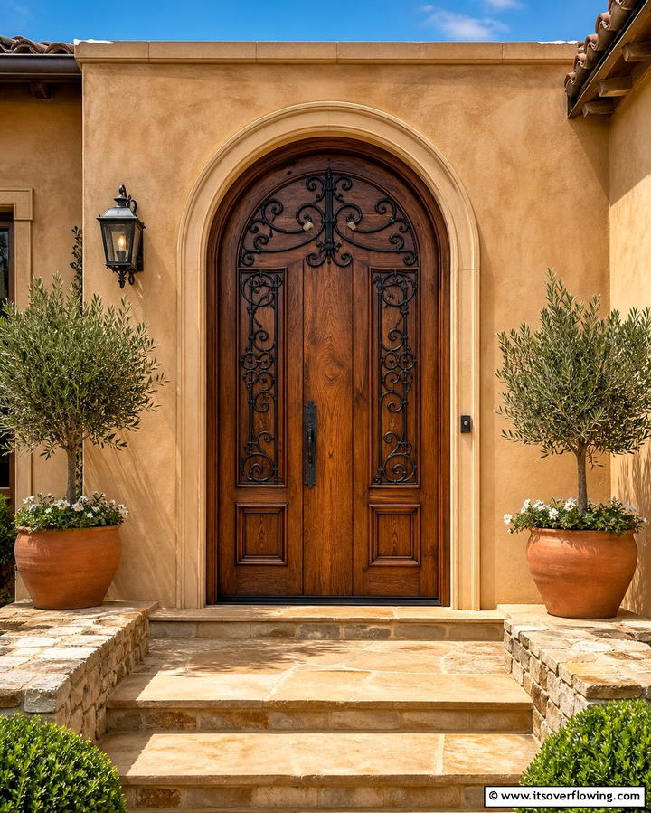 Arched Wooden Door with Iron Accents - 25 Mediterranean Front Door Ideas for a Warm Welcome