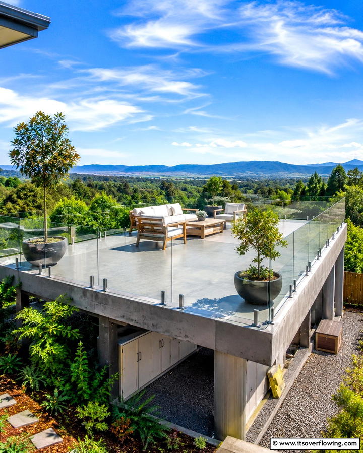Elevated Concrete Deck with Glass Railings - 25 Concrete Deck Ideas for a Modern and Durable Outdoor Space
